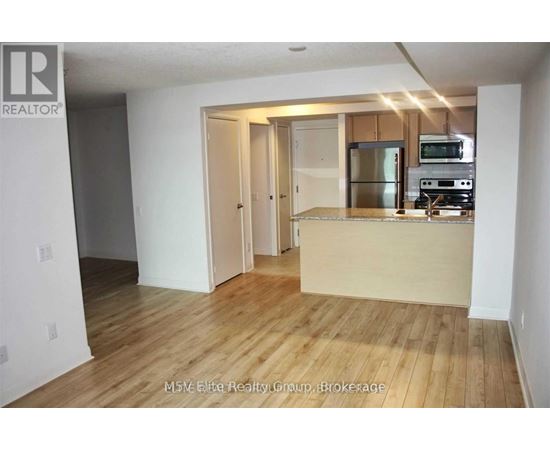 A kitchen area with a refrigerator, microwave, and oven.