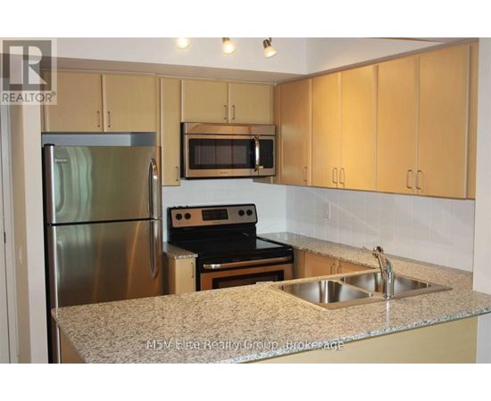A kitchen with a stainless steel refrigerator, microwave, oven, and sink.