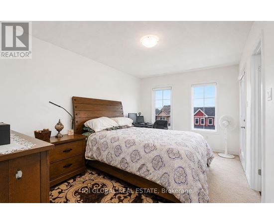 A bedroom with a bed, nightstand, and window.