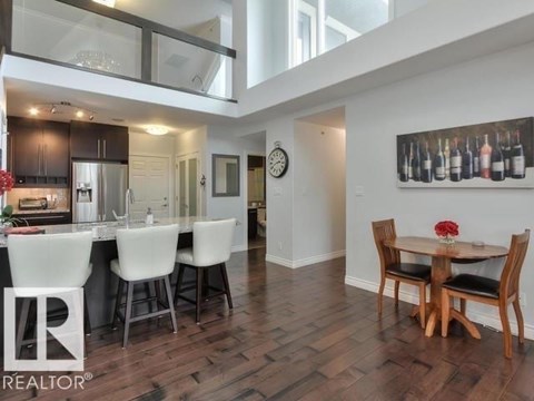 A modern kitchen with a dining table set for two.
