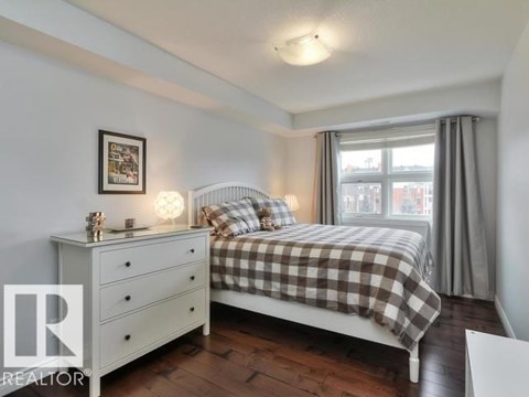 A bedroom with a bed, nightstand, and window.