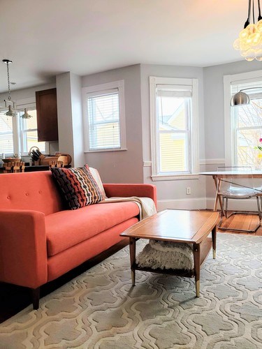 A living room with a red couch and a wooden coffee table.