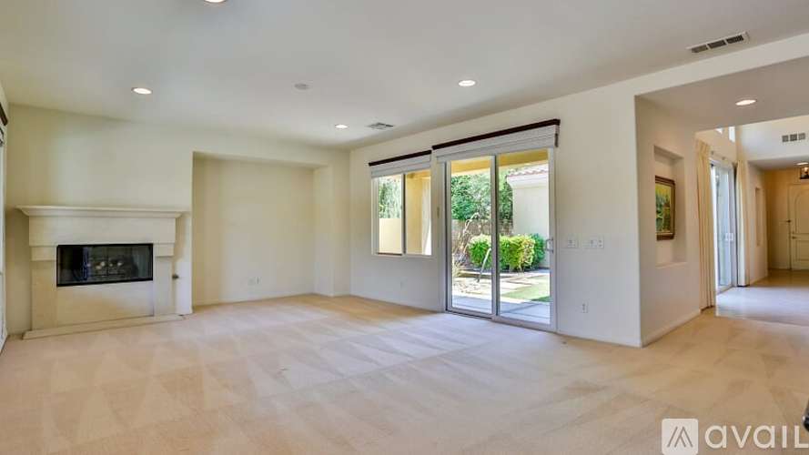 A spacious living room with a fireplace and sliding glass doors.