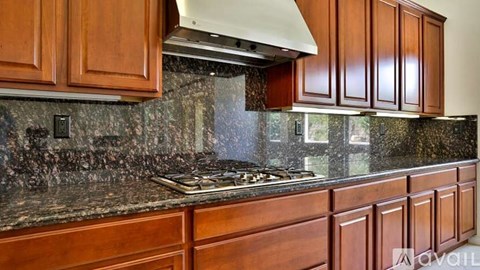 A kitchen with wooden cabinets and a granite countertop.