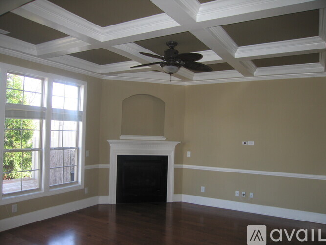 A living room with a fireplace and a ceiling fan.