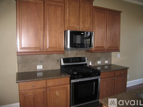 A kitchen with wooden cabinets and a black stove top oven.