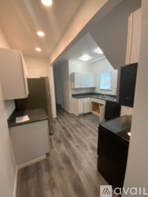 A kitchen with black countertops and white cabinets.