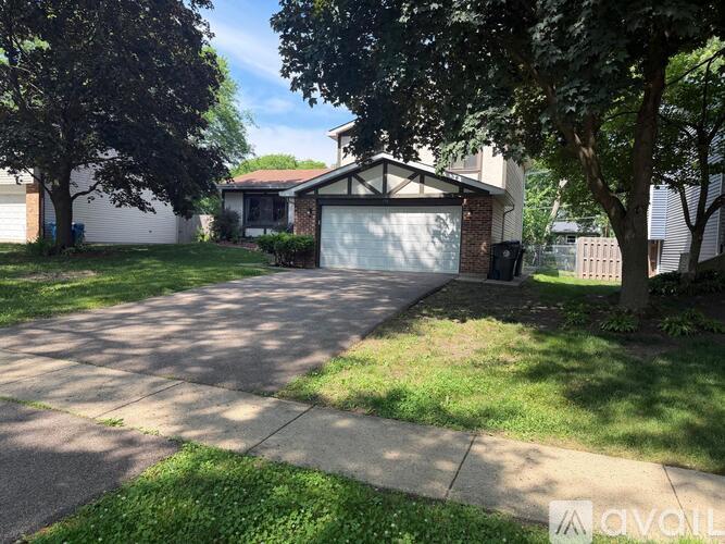 A house with a driveway and trees in front.