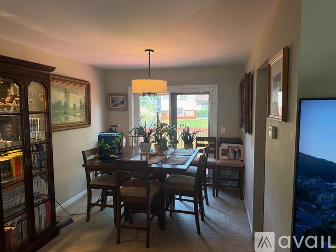 A dining room with a table set for six and a fish tank.