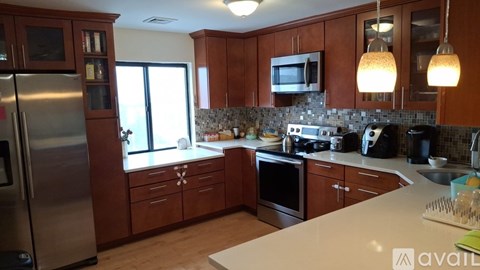 A kitchen with wooden cabinets and a white counter top.