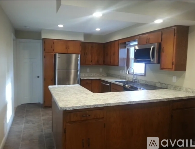 A kitchen with wooden cabinets and a granite countertop.