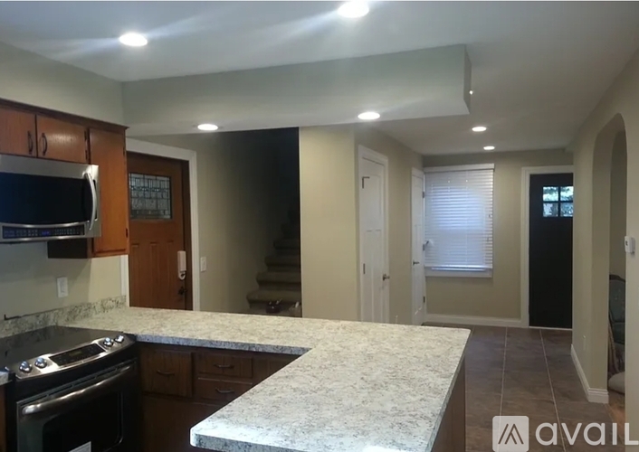 A kitchen with a marble countertop and a stove top oven.