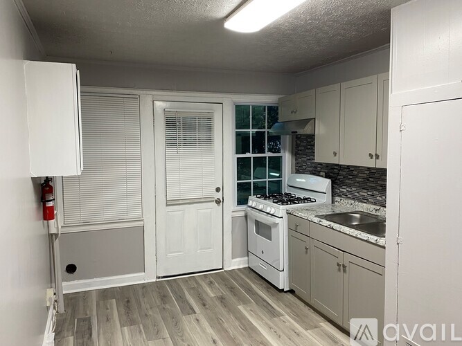 A kitchen with white appliances and cabinets.