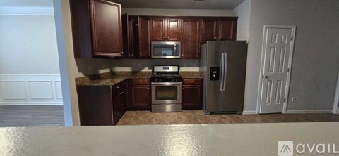A kitchen with brown cabinets and a refrigerator.