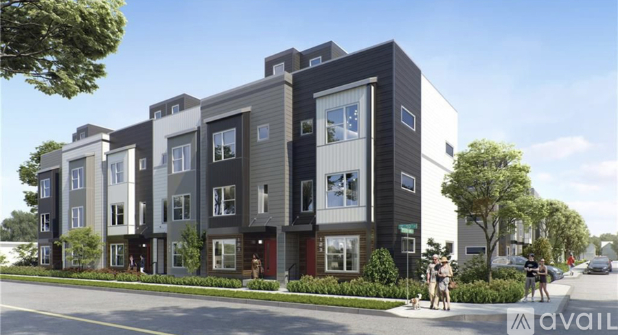 A modern apartment building with multiple balconies and a street in front.