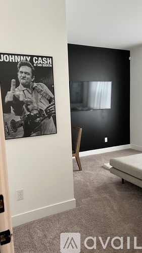 A poster of Johnny Cash is hanging on a wall above a bed in a room.