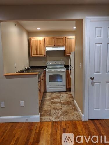 A kitchen with wooden cabinets and a white refrigerator.