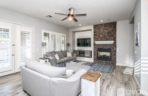 A modern living room with a grey sofa and a fireplace.