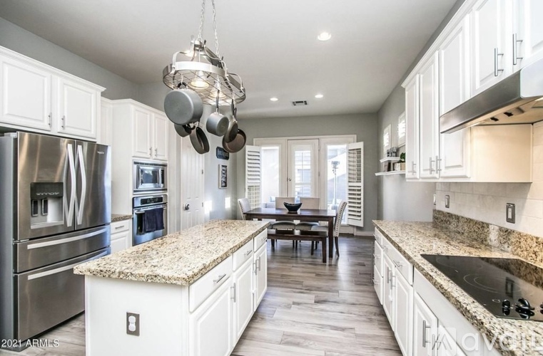 A modern kitchen with granite countertops and stainless steel appliances.