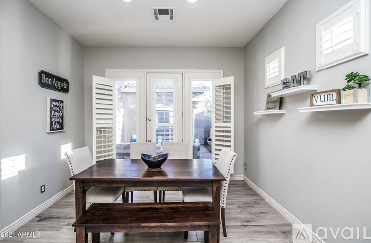 A dining room with a wooden table and chairs.