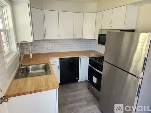 A kitchen with a stainless steel refrigerator, sink, and black dishwasher.