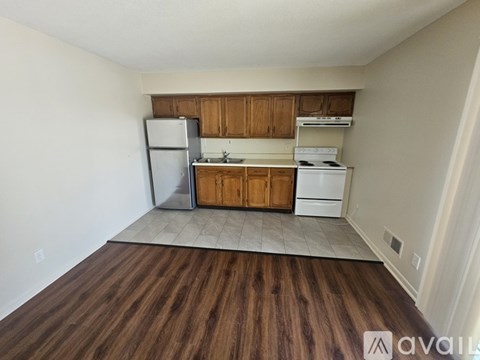 A kitchen with wooden cabinets and a white fridge.