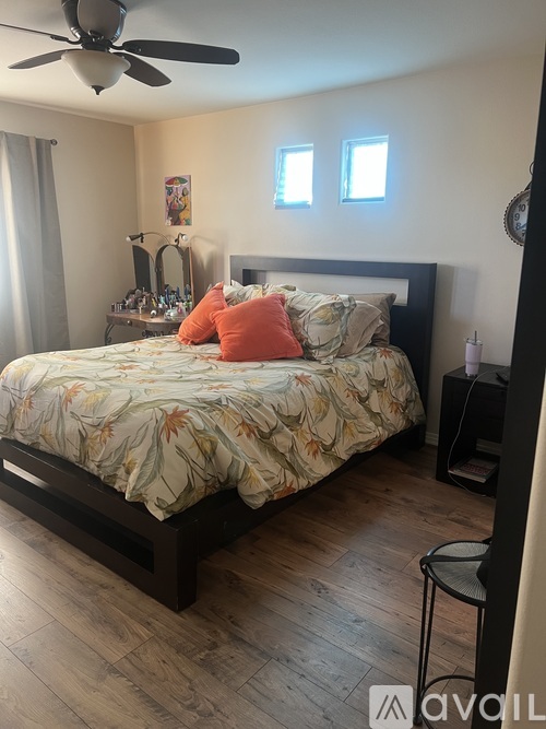 A bedroom with a large bed and a ceiling fan.