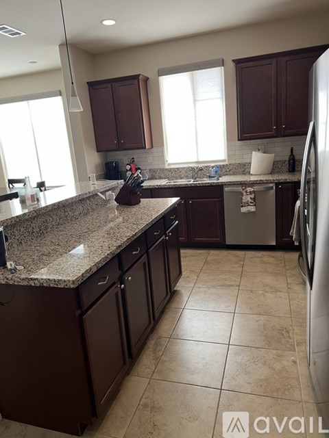 A kitchen with brown cabinets and a granite countertop.