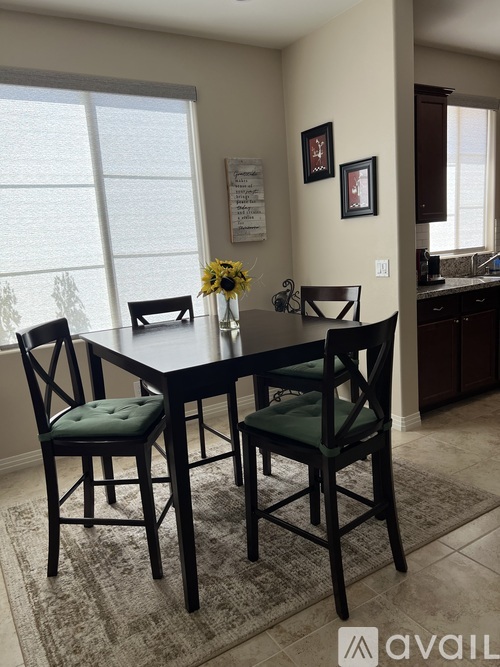 A dining room with a table and chairs.