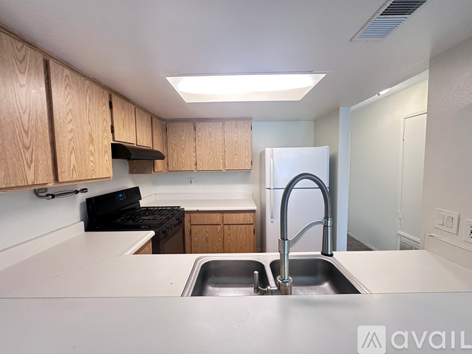 A kitchen with wooden cabinets and a stainless steel sink.