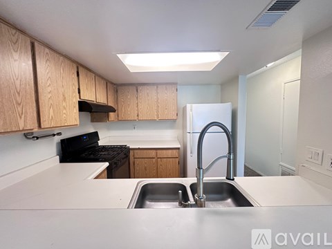 A kitchen with wooden cabinets and a stainless steel sink.