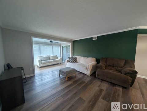 A living room with a white couch and a brown couch.