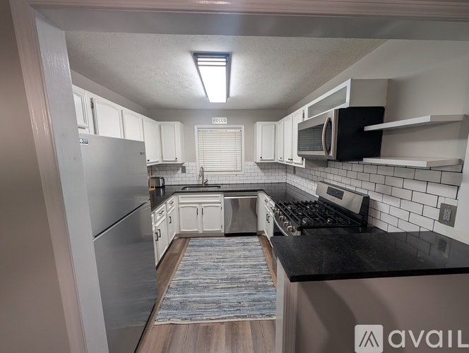 A kitchen with a refrigerator, microwave, and oven.