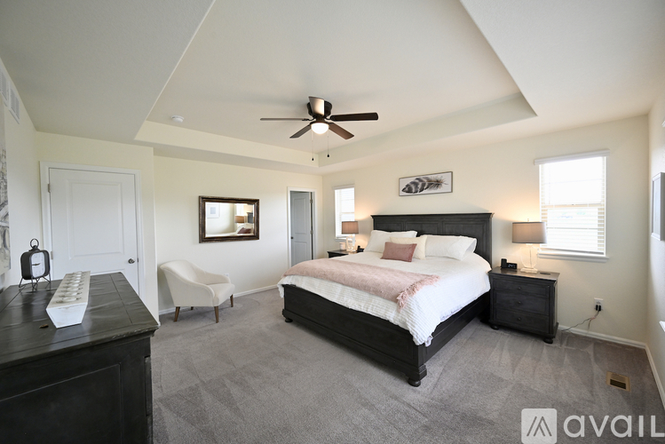 A bedroom with a large bed and a ceiling fan.