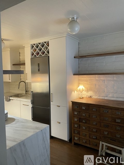A kitchen with a black fridge and a white counter top.