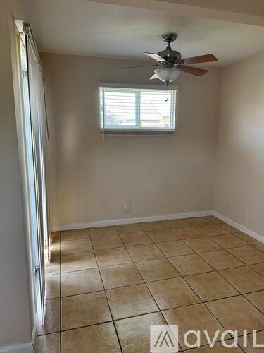 A room with a ceiling fan and a window.