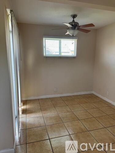 A room with a ceiling fan and a window.