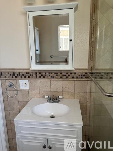 A bathroom with a white sink and a mirror above it.