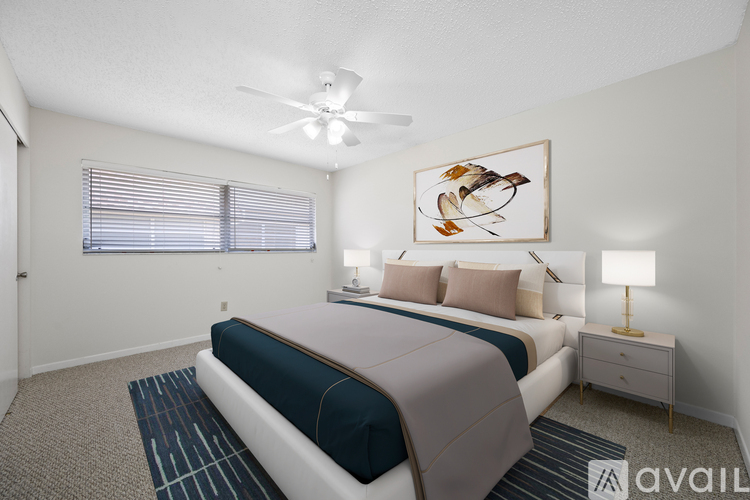 A bedroom with a bed, nightstand, and a ceiling fan.