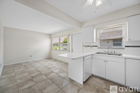 A kitchen with white cabinets and a tiled floor.