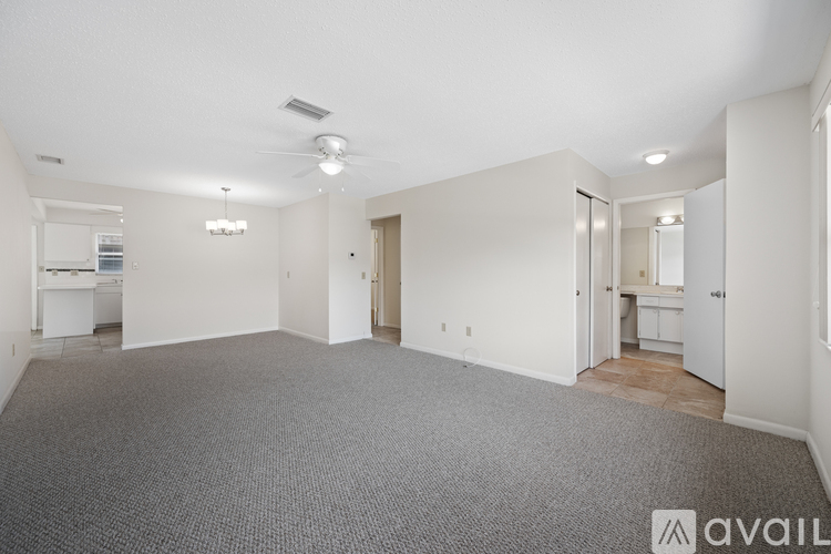 A spacious, empty room with a carpeted floor and white walls.