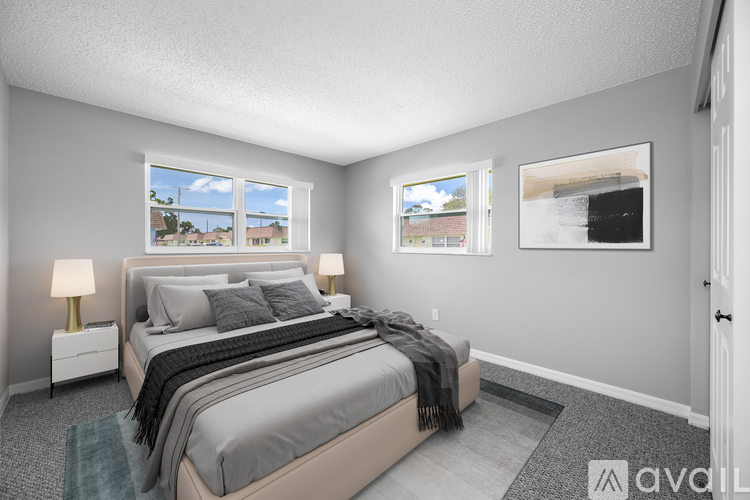 A bedroom with a large bed and two windows.