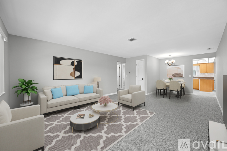 A living room with a grey carpet and a white sofa.