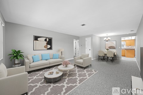 A living room with a grey carpet and a white sofa.
