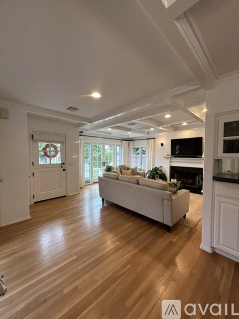 A living room with a white couch and wooden floors.