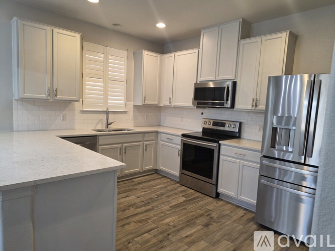 A kitchen with white cabinets and stainless steel appliances.