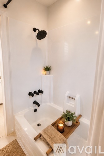 A white bathroom with a tub and a plant.