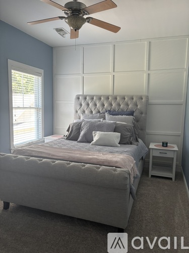 A bedroom with a large bed and a ceiling fan.