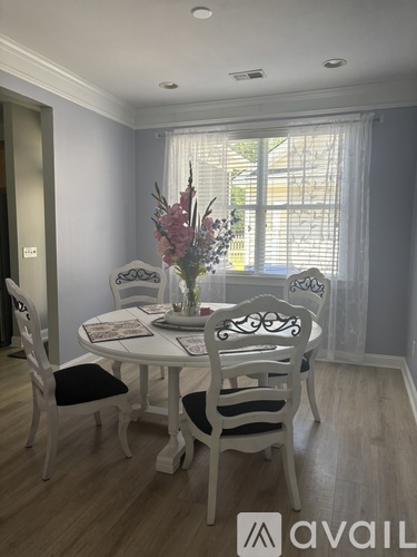 A dining room with a white table and chairs.