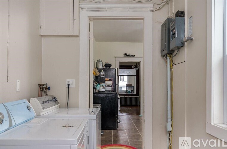 A kitchen with a white counter and a white fridge.